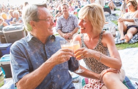 A couple raises their glasses on the Lawn
