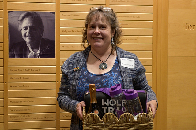 Raffle winner Rebecca Young poses next to a portrait of Catherine Filene Shouse.