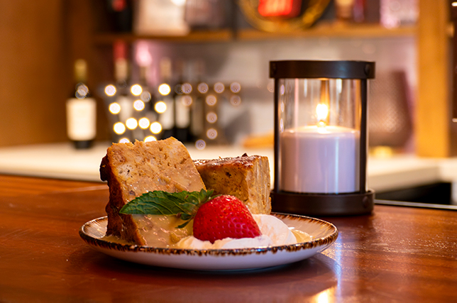 Slices of pumpkin bread pudding with a strawberry on a plate.