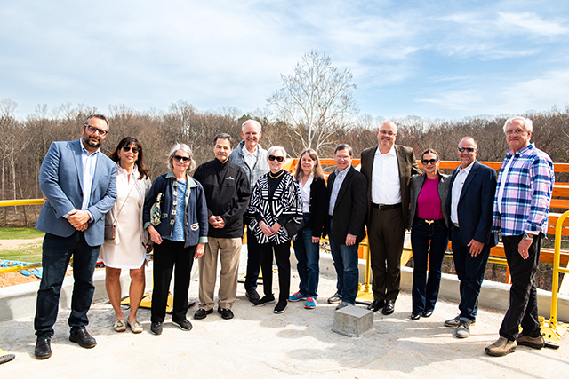 Group of visionary donors posing outside the Meadow Commons construction.