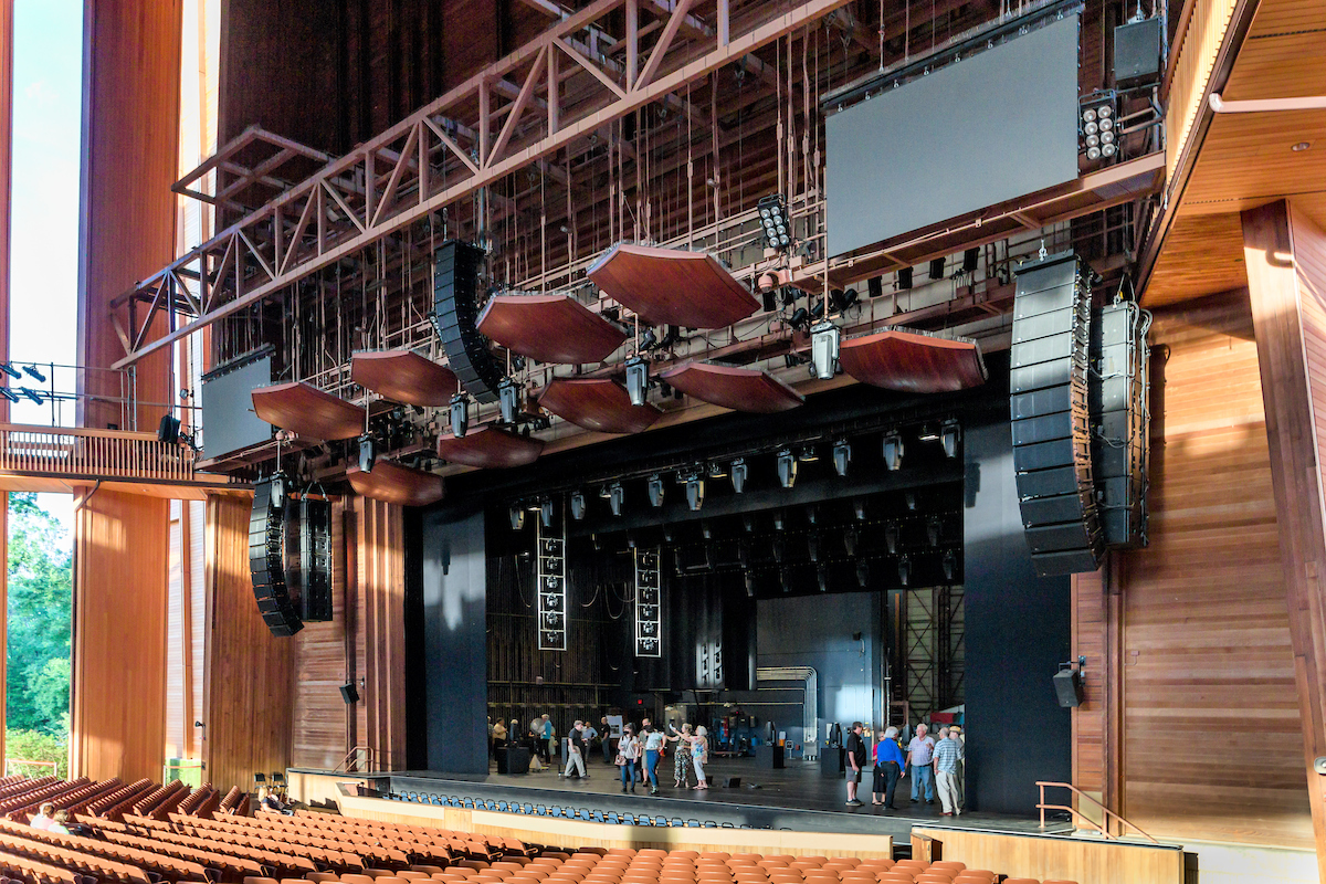 The Filene Center stage viewed from the seats, with members exploring the backstage spaces.