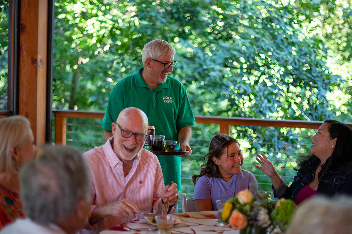 Volunteer serves members at a member dinner event.