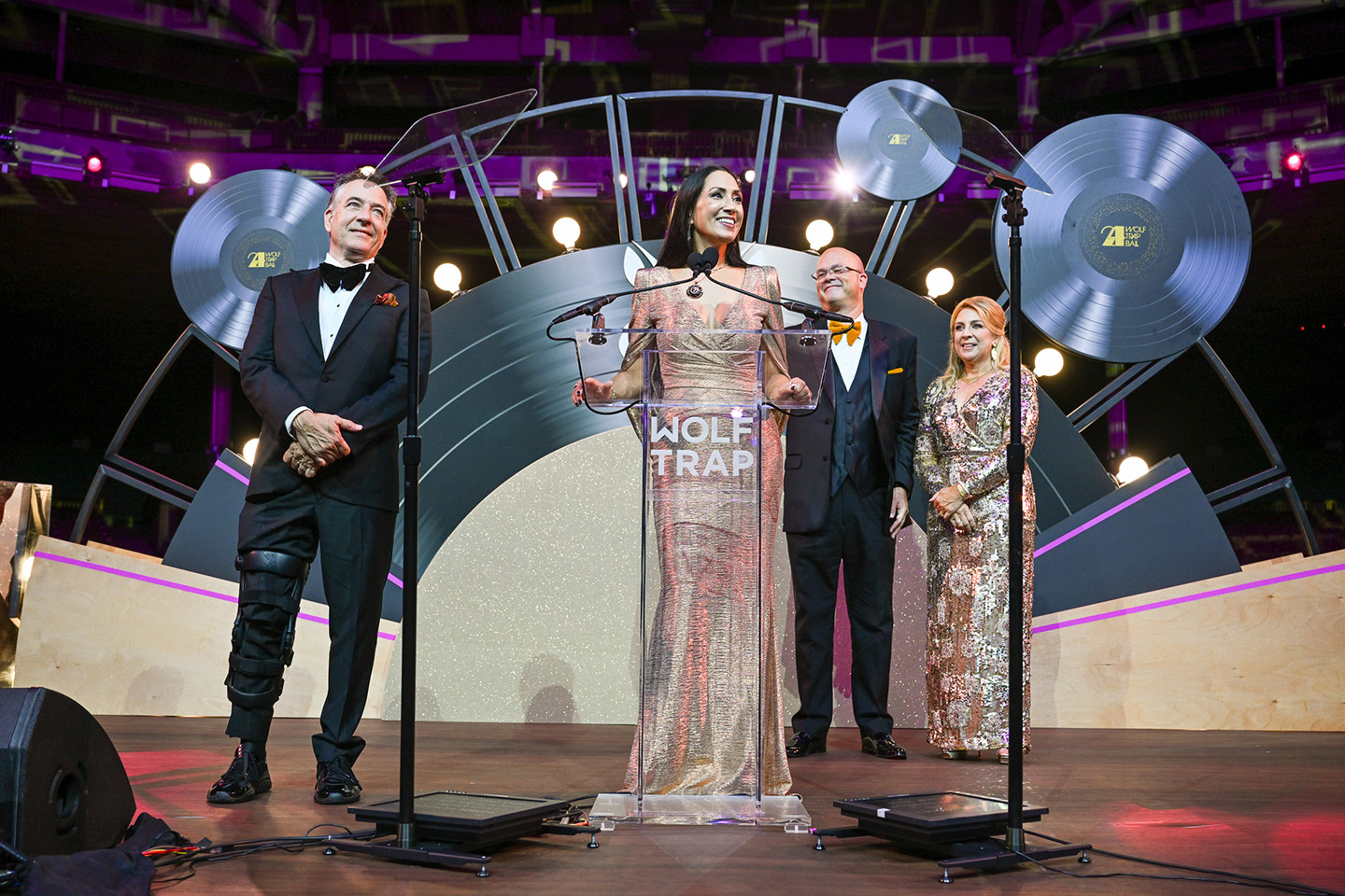 Ball Co-Chairs on a stage adorned with gold and giant records.