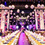 Long tables set up for a formal dinner, with hundreds of disco balls above.