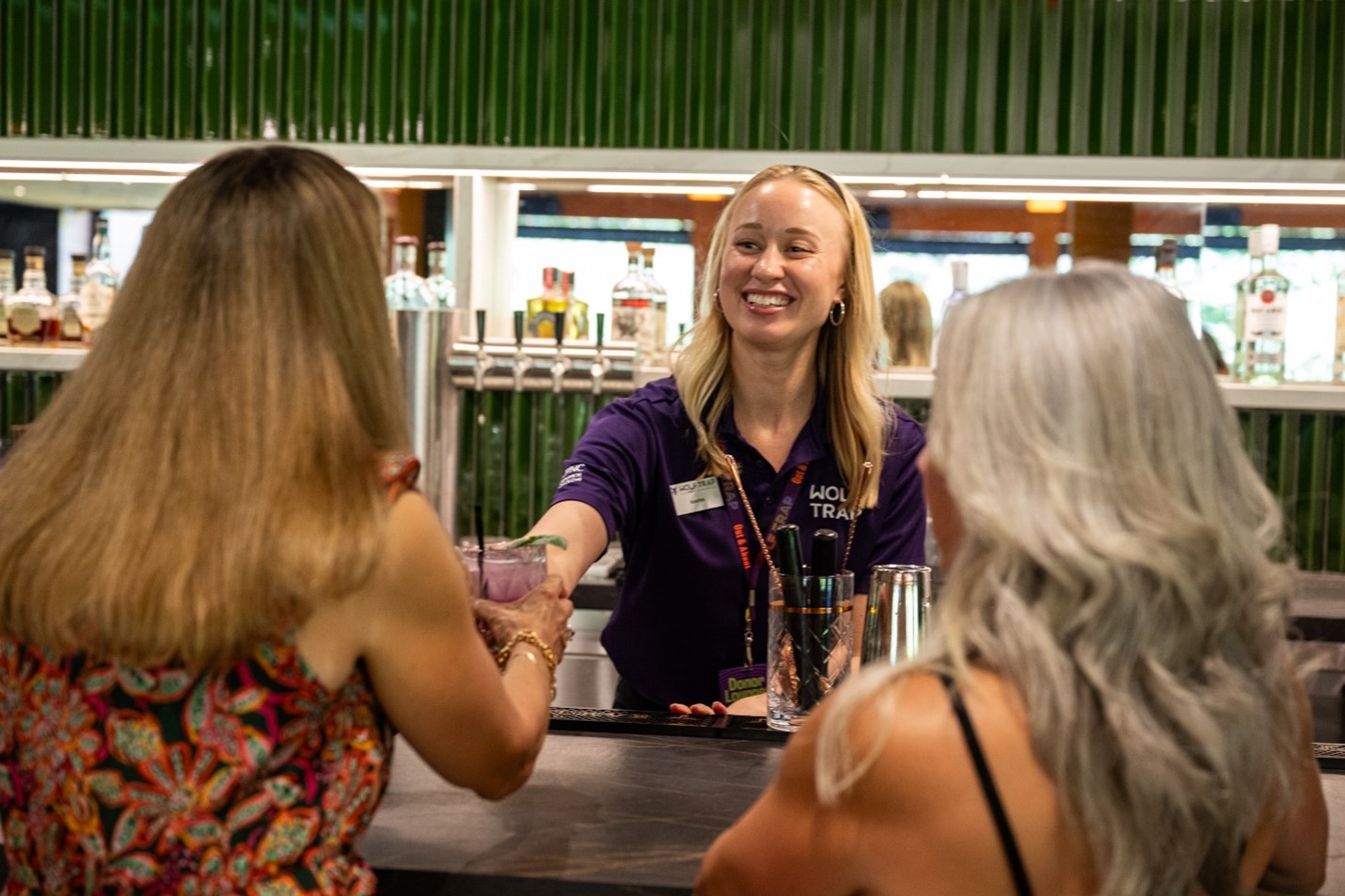 Meadow Lounge server gives a drink to a member.