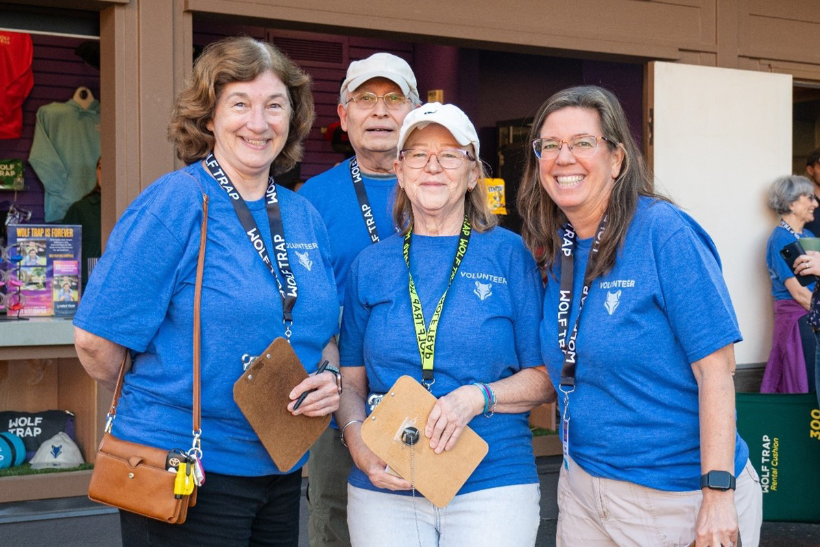 Four volunteers at the gift shop holding clipboards.