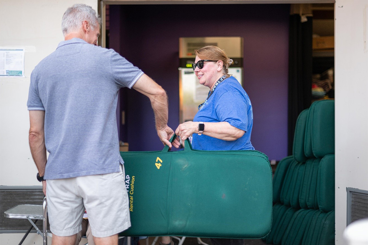 Wolf Trap volunteer assists a patron with a chair rental.