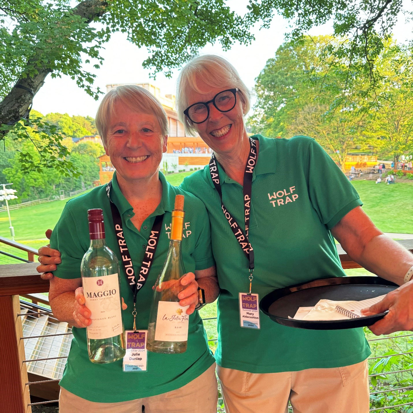 Two Wolf Trap volunteers working as servers at a member dinner.