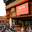 "Thank You PNC" displayed on a screen outside The Filene Center, with lots of patrons on the Lawn before a concert.