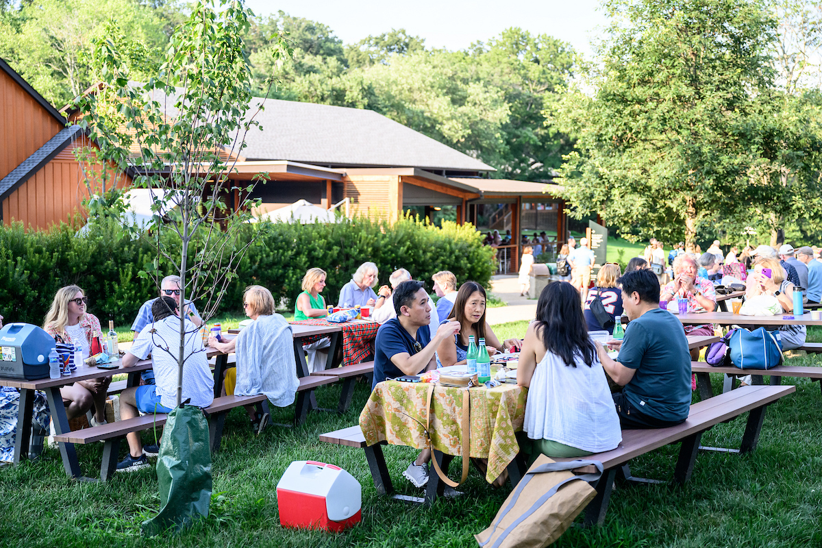 Wolf Trap picnic tables covered with colorful cloths and surrounded by happy patrons.