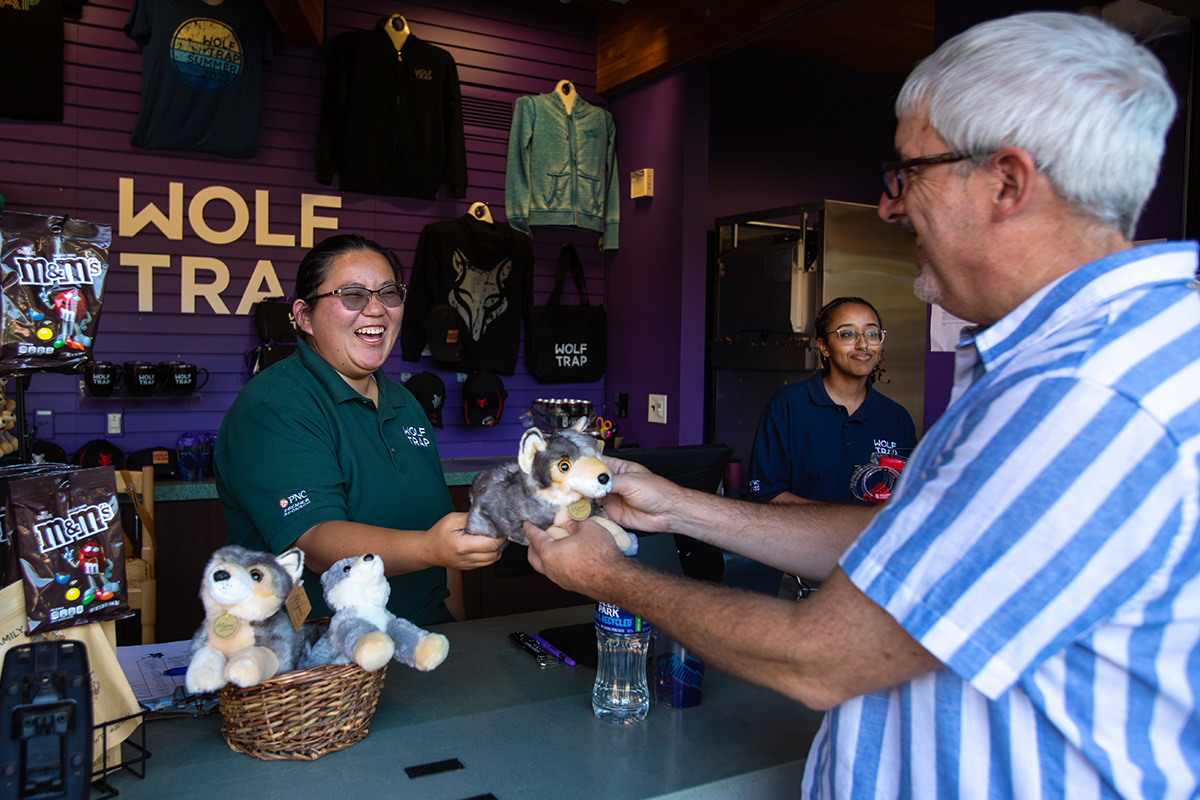 Wolf Trap member buys a cute stuffed wolf toy at the Wolf Trap gift shop.