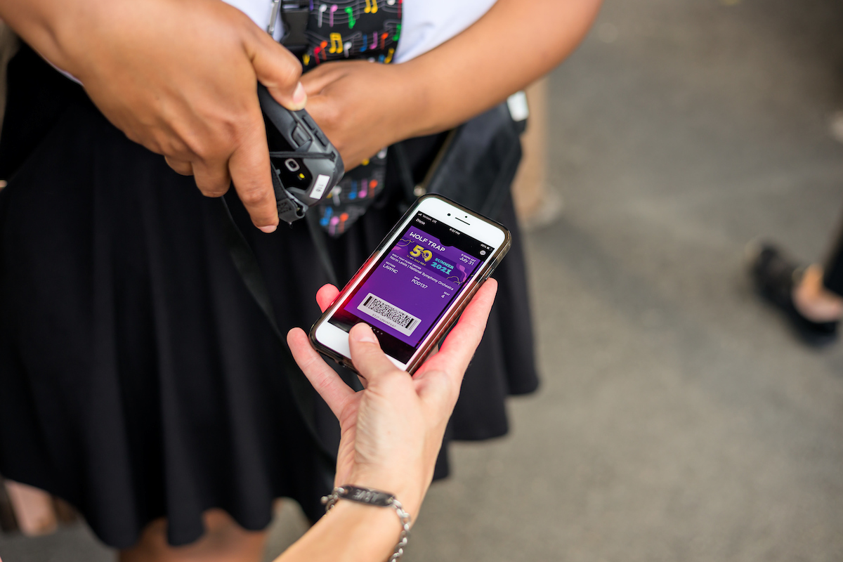 Closeup of a park volunteer scanning a Wolf Trap ticket on a mobile phone.