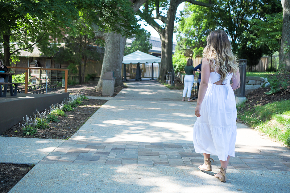 Woman in a white dress walks along the Meadow Overlook Path towards the Filene Center.