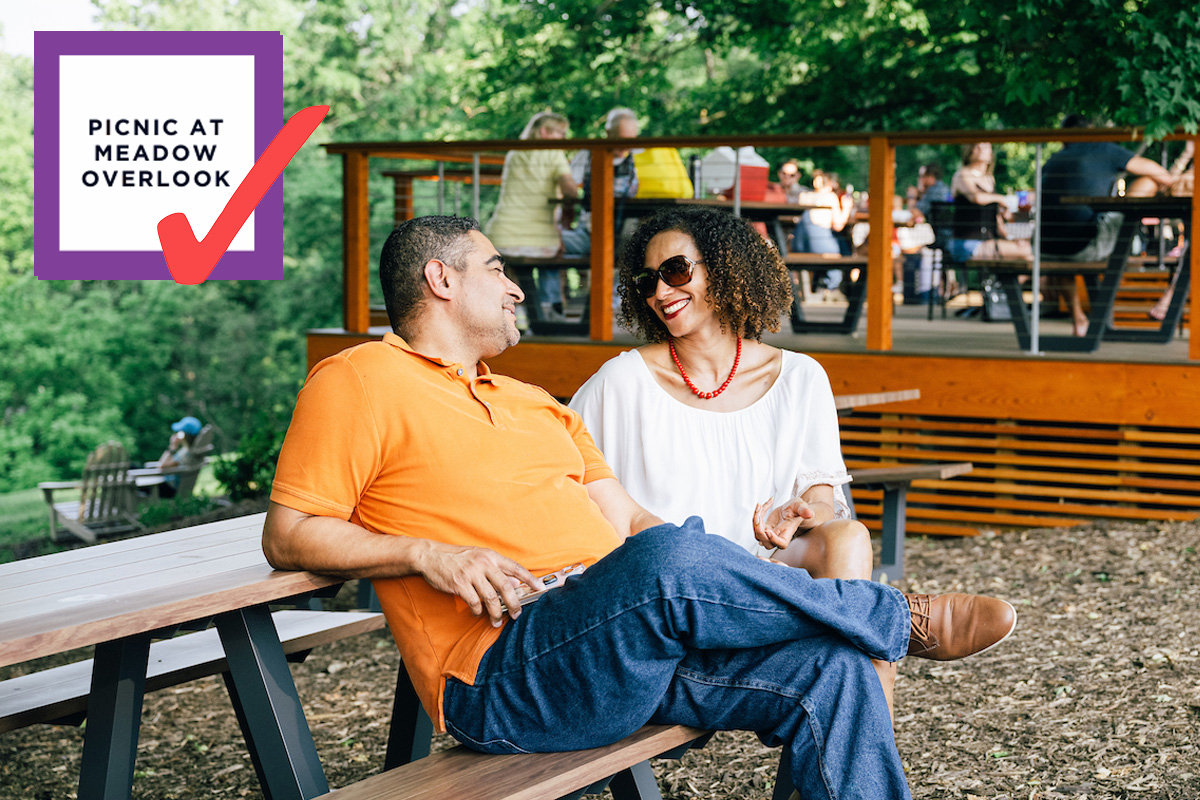 Bingo card item "Picnic at Meadow Overlook" checked off, next to a photo of a couple smiling at a Meadow Overlook picnic table.